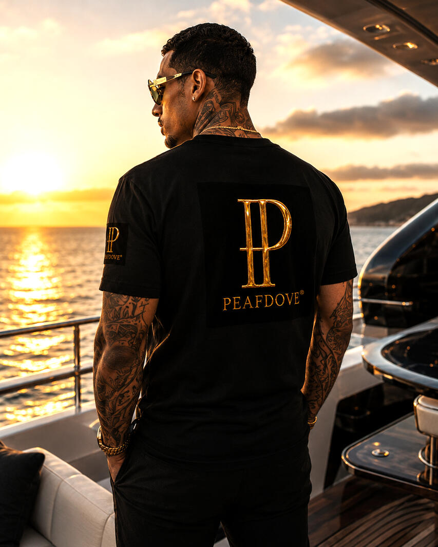 Quiet luxury. Visible authority. The PEAFDOVE® Gold Monogram Shirt carries the gilded PEAFDOVE signature as a controlled statement across the chest. No loud graphic. No overloaded design. Just one unmistakable symbol for men who never need to explain.